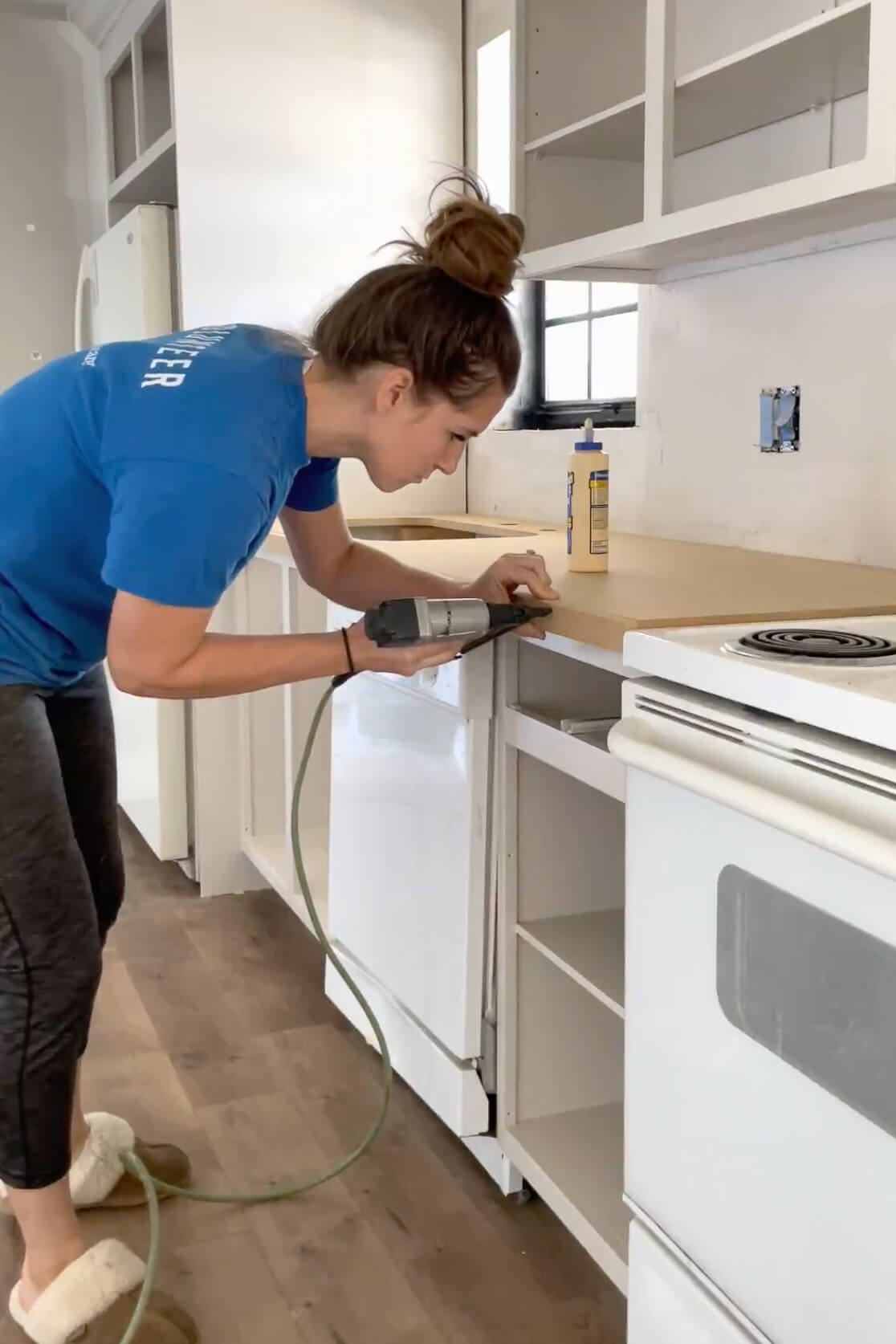 Using a brad nailer to attach the edge of a DIY wood countertop.